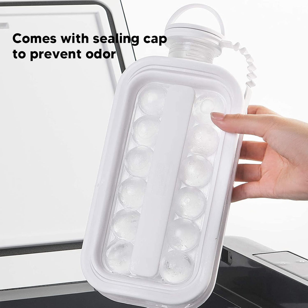 Hand holding the ice ball maker bottle full of frozen round ice balls, cap closed