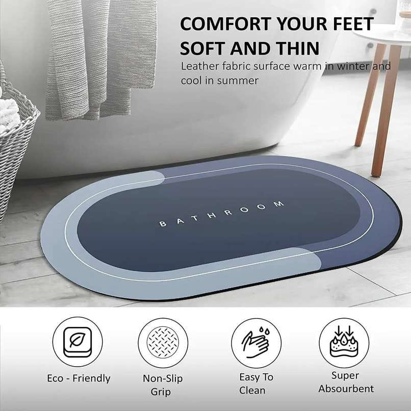 Navy and blue oval absorbent mat printed with BATHROOM, in front of a bathtub